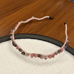 Detail of pink fabric headband adorned with polished natural stones and beads