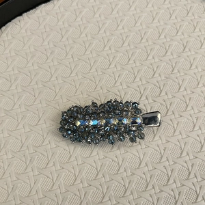 Detail of handmade deep blue crystal hair clip with iridescent rectangular stone inlay