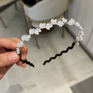 Détail de cristaux de zircon en forme de feuille sur un serre-tête ondulé noir élégant