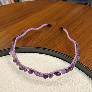 Close-up of handmade purple crystal stone headband with wrapped fabric and metal base