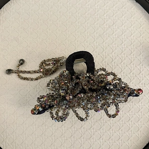 Detail of handcrafted hair claw clip with grey crystal flowers and beaded tassels