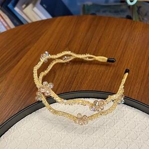 Close-up of double-layer headband with champagne crystal beads and golden thread