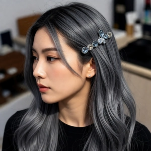 Detailed close-up of a blue crystal bow hairpin worn on elegant wavy grey hair