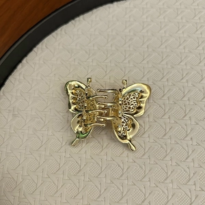 Détail de la pince à cheveux papillon dorée avec motifs ajourés et fini métal poli
