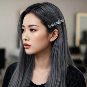 Luxurious silver crystal bow hair clip with blue gemstones worn on elegant grey hair