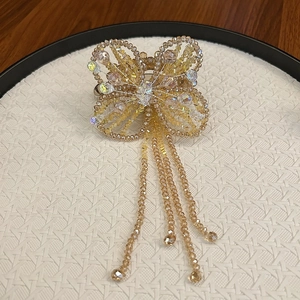 Macro shot of handcrafted beaded butterfly hair clip with shimmering beaded tassels