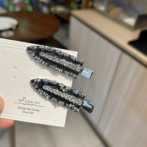 Close-up of luxury handcrafted crystal beads and rhinestones on black side hair clips