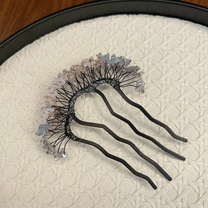 Detail view of handmade beaded hair comb with pink and blue crystal stones on black metal frame