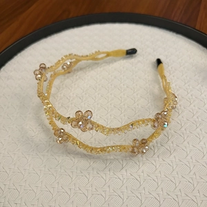Macro view of double-layer wave headband featuring champagne crystal floral details