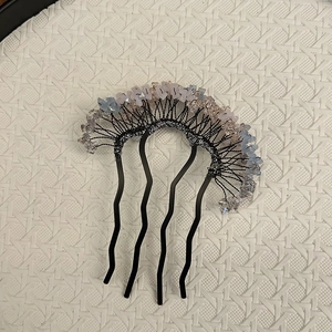 Detail of handmade hair comb with blue and pink crystal beads on black metal pins