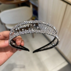 Close-up of handmade luxury crystal headband with silver rhinestones and woven black base