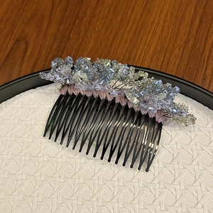 Detailed macro view of handmade crystal hair comb with blue and silver floral beadwork