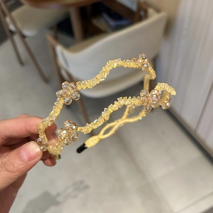 Detailed close-up of amber crystal beaded wave headband with delicate floral accents
