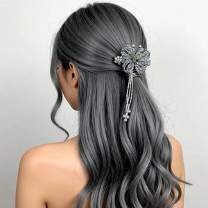Elegant beaded flower hair clip with tassels and green crystal on wavy grey hair
