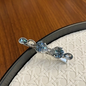 Elegant silver metal hair clip featuring premium blue and clear crystal bow design