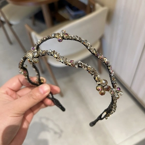 Double-layered wavy headband featuring sparkling champagne crystals and retro woven design