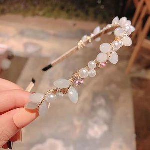 Détail du serre-tête en perles avec pétales blancs mats et cristaux sur monture dorée