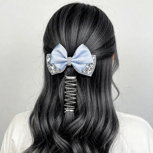 Close-up of light blue satin bow hair clip with rhinestones and silver spiral headband