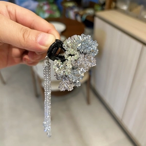 Detail view of crystal hair claw clip with light blue beads and long beaded tassel