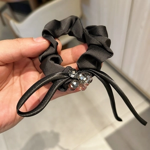 Detail of satin scrunchie with hand-sewn crystal beads and elegant bow decoration
