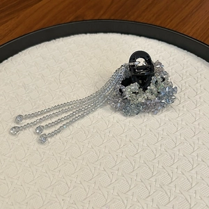Detailed macro of a crystal-beaded hair claw clip featuring elegant hanging tassels