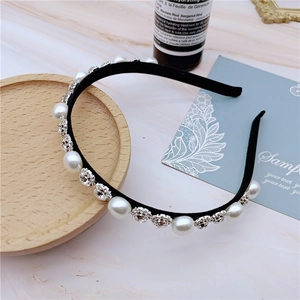 Detail shot of elegant pearl and rhinestone headband on marble background