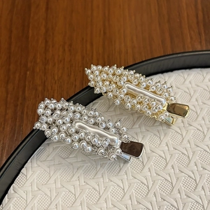 Close-up of luxury handmade hair clips featuring small white pearls and alloy duckbill clips