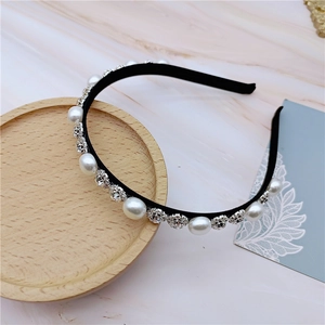 Detail of thin hairband featuring white pearls and rhinestone snowflake accents