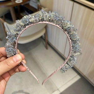 Close-up of handmade luxury crystal headband with pink satin base and sparkling beads