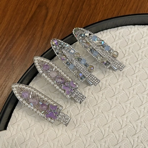Detail of luxury beaded hair clips with purple crystals, pearls and rhinestone accents