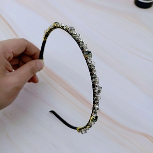 Elegant French vintage hairband with gray crystals and gold wire on marble background