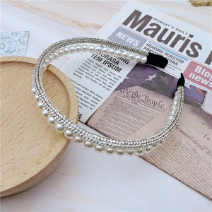 Detail of vintage pearl headband with rows of sparkling rhinestones on metal frame