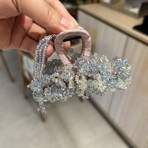 Detailed shot of handmade blue and purple crystal hair claw with beaded tassels