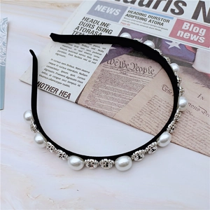 Elegant black velvet headband with pearls and rhinestones on a vintage background