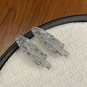 Detailed close-up of handmade luxury hair clips with crystals and blue gemstones