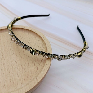Detailed macro of a French style headband featuring gold wire wrap and crystal beads