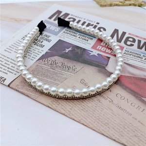 Elegant headband with white pearls and sparkling rhinestones on a vintage background