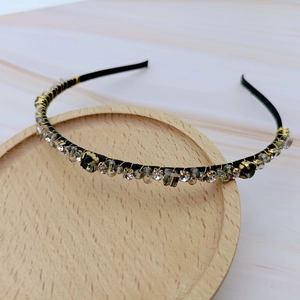 Detail of vintage French headband with grey crystals and rhinestones on wood base