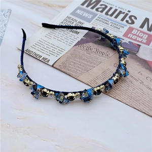 Détail du serre-tête élégant en cristal bleu foncé avec perles sur marbre blanc