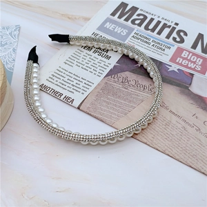 Detail of elegant headband with double rows of rhinestones and white pearls on gold base