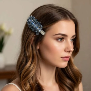 Handcrafted blue crystal beaded hair clip worn on long wavy hair for an elegant side-swept look