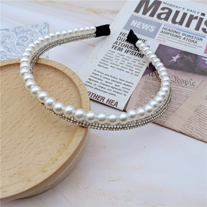 Detailed view of double-layer headband with large white pearls and sparkling rhinestones