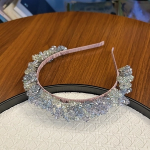 Detail view of pink satin headband featuring dense sparkling crystal and silver beadwork
