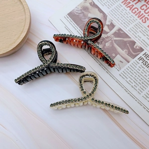 Tre eleganti pinze per capelli francesi con perle e strass su sfondo di marmo chic