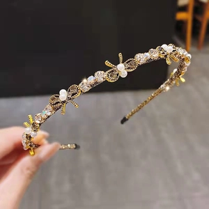Elegant gold headband with rhinestones and white pearls in a delicate butterfly design