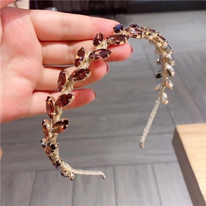 Close-up of vintage baroque metal leaf headband with marquise-cut reddish brown gemstones