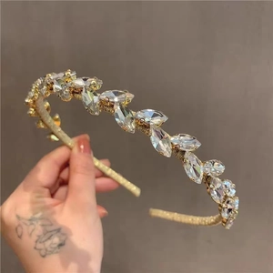Detailed macro view of delicate gold metal headband with sparkling marquise rhinestones