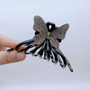 Detail of butterfly hair claw clip with champagne rhinestones and black resin finish