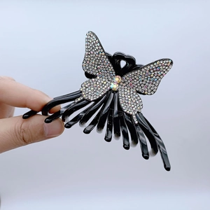 Macro detail of butterfly hair claw with sparkling colorful rhinestones on black resin