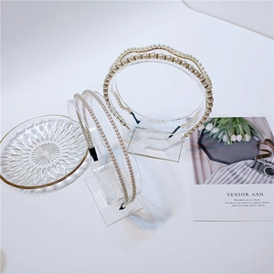 Detailed view of elegant pearl headbands with golden metal rings on a decorative display